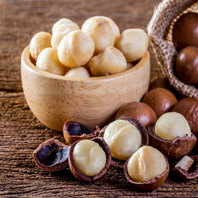 Macadamia nuts with packaging in wooden bowl