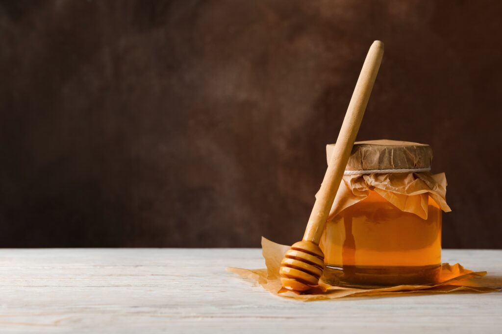 Honey jar and comb on wood